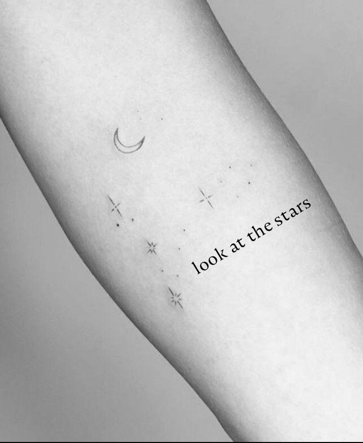 a person's arm with the words look at the stars written on it in black ink