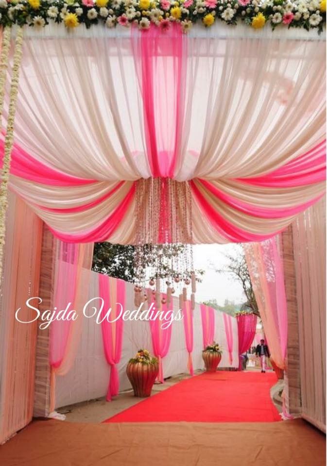 an outdoor ceremony with pink and white draping, yellow flowers and greenery