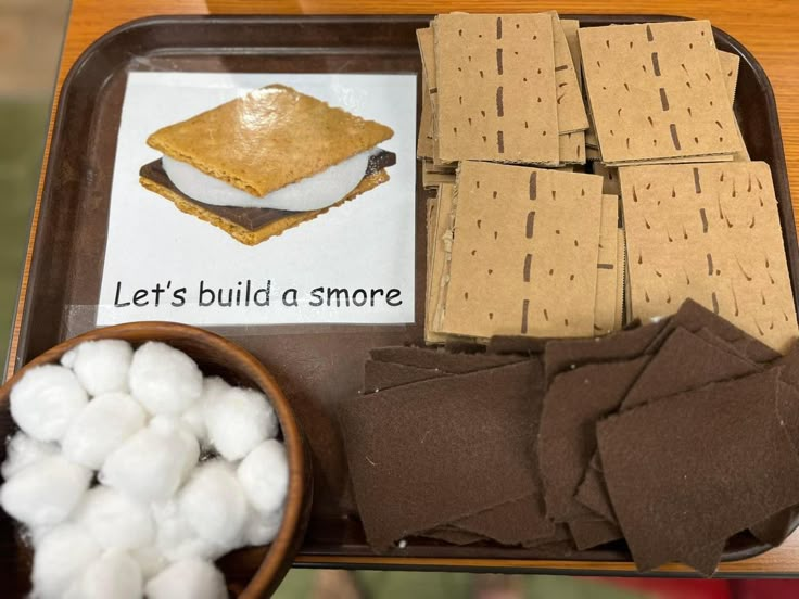 a tray filled with marshmallows and crackers on top of a table