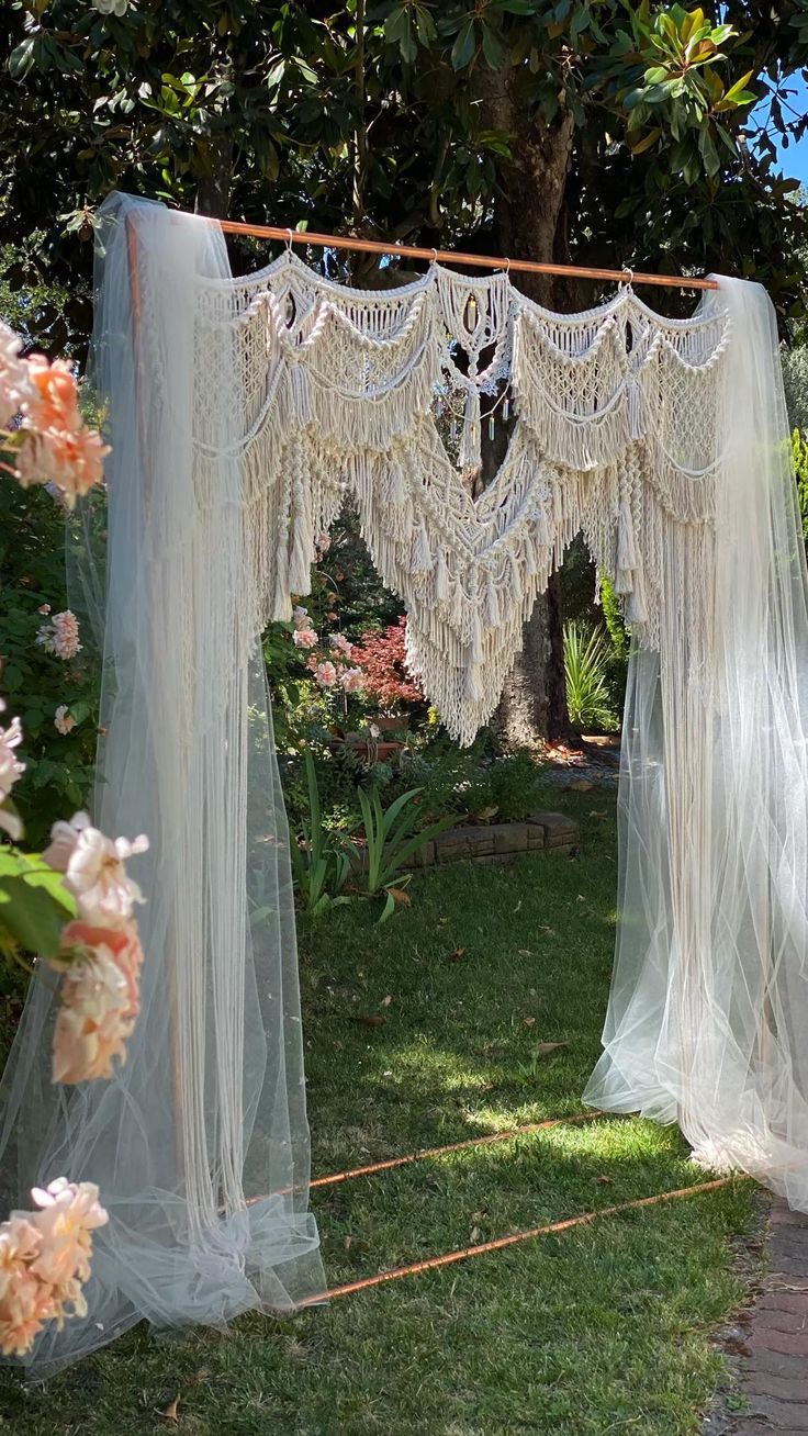 an outdoor area with white curtains and flowers