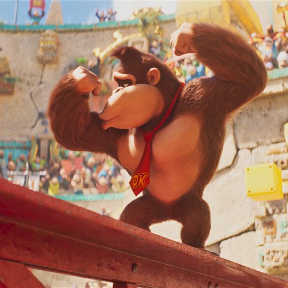 a monkey dressed in a tie standing on a rail at an amusement park with people watching