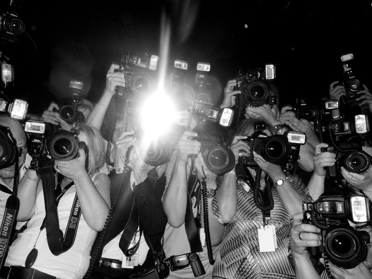 a group of people holding up cameras in front of their faces and taking pictures with them