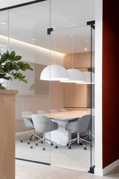 an office with glass walls and white chairs