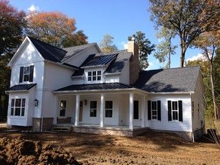 a large white house sitting on top of a dirt field