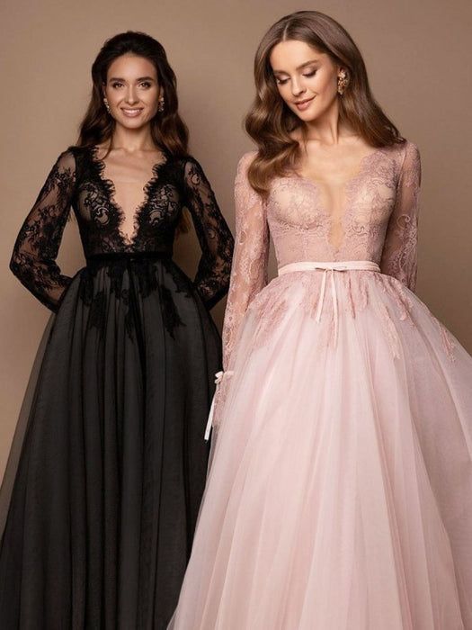 two women standing next to each other wearing dresses with long sleeves and bows on the waist