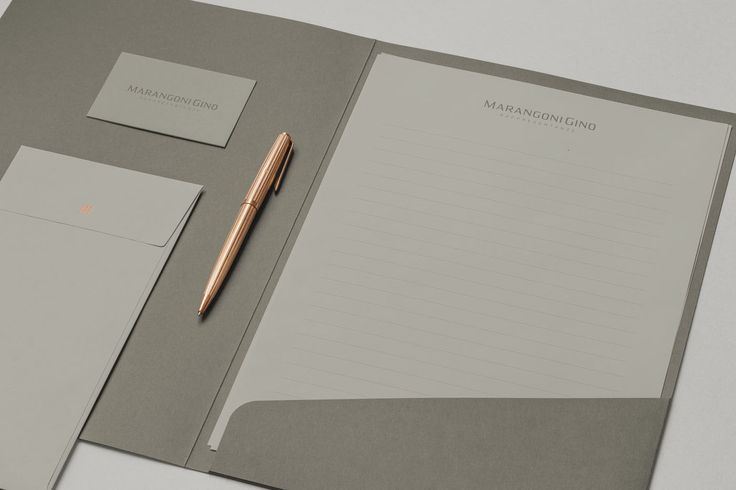 a notepad and pen on top of a gray folder with two sheets of paper next to it