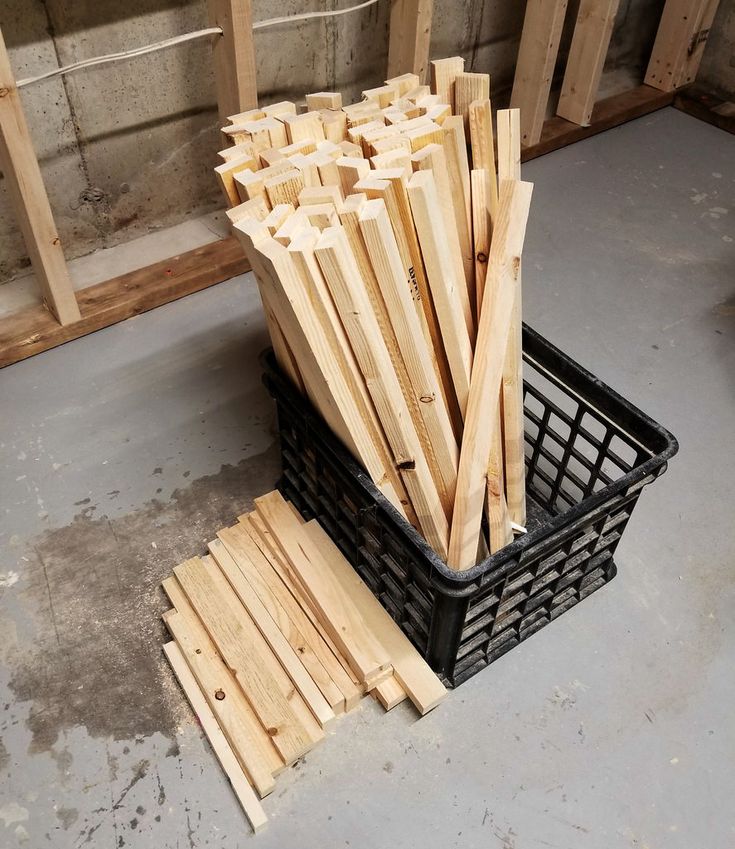 a basket full of wooden planks sitting on the floor