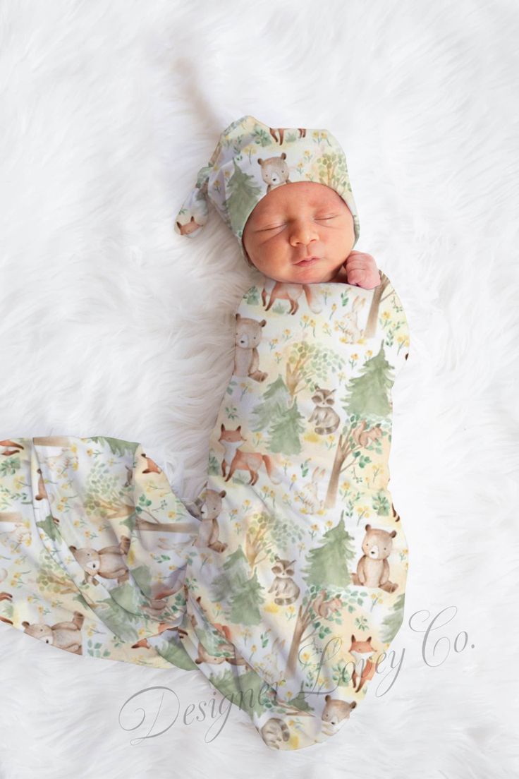 a newborn baby is laying on a white blanket wearing a bear print outfit and hat