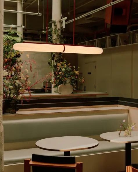 the interior of a restaurant with tables, chairs and planters on the counter top