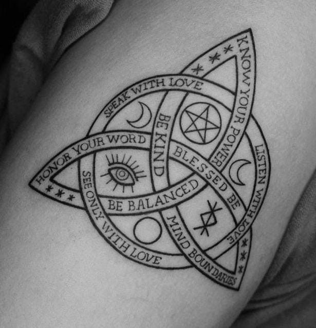 a black and white photo of a woman's thigh with an illuminate tattoo on