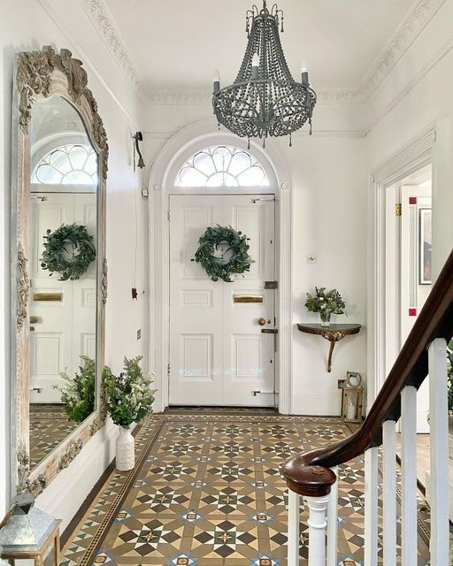 an entryway with a chandelier and potted plants