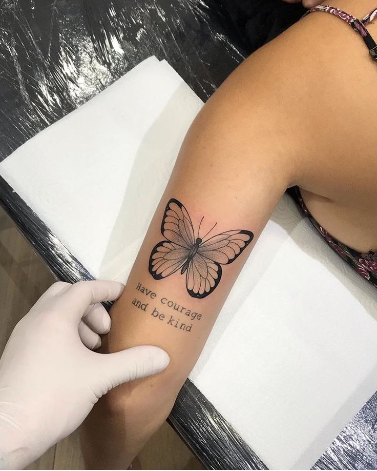 a woman with a butterfly tattoo on her arm