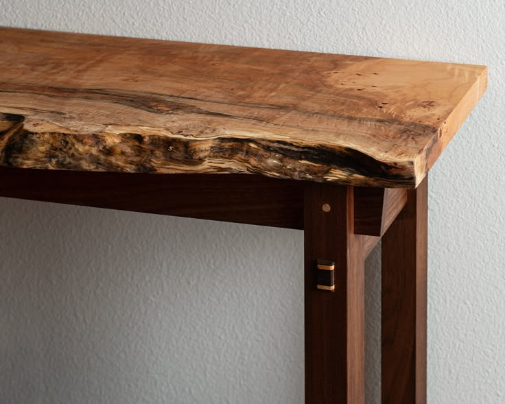 a piece of wood sitting on top of a wooden table next to a white wall