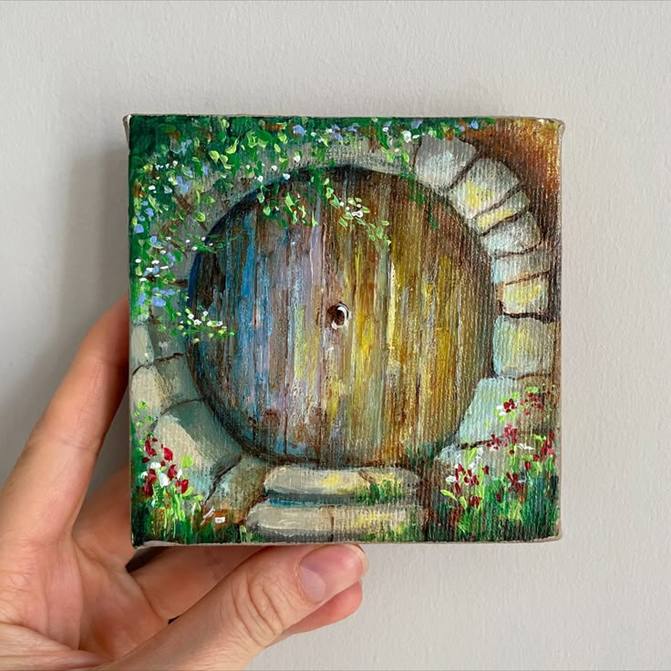 a painting of a hobbot door in someone's hand