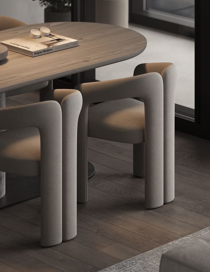 a dining room table with four chairs and a book on the table next to it