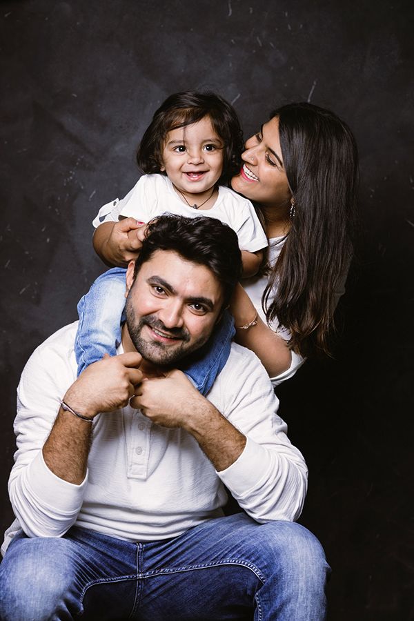 a man sitting on top of a woman's lap while she holds her child