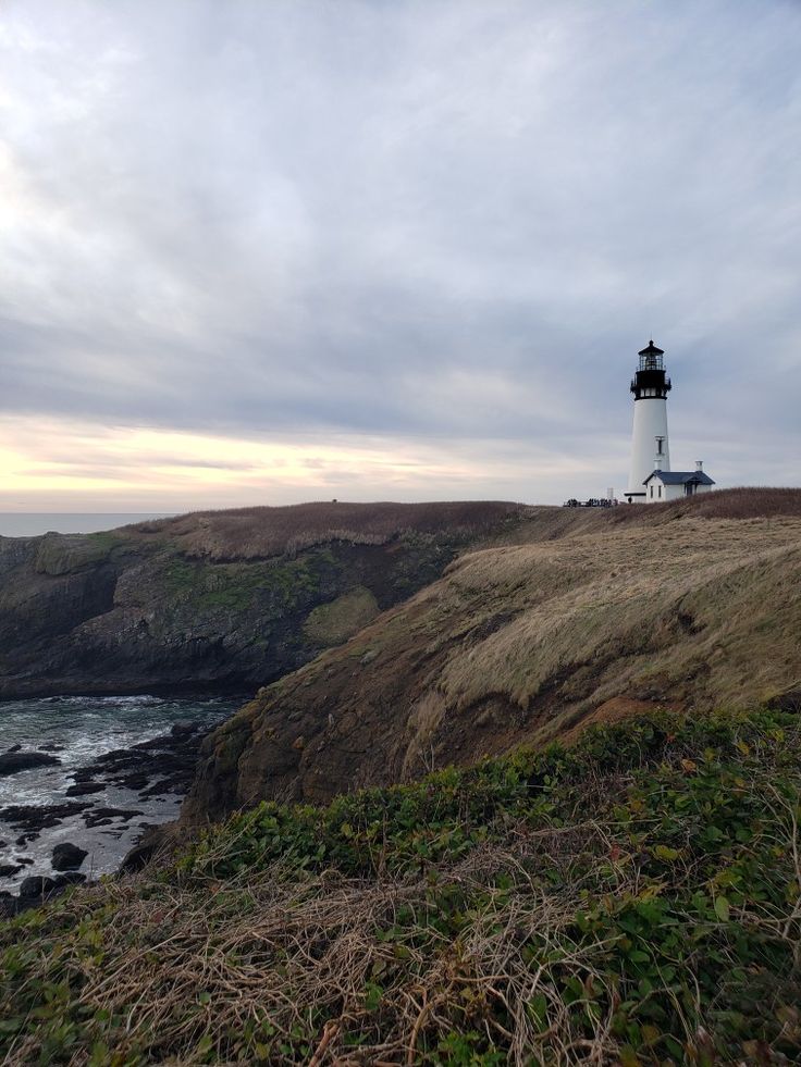 a light house sitting on top of a cliff next to the ocean