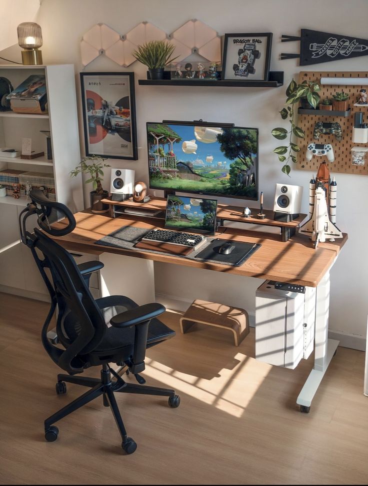 a desk with a computer and speakers on it in front of a wall full of pictures