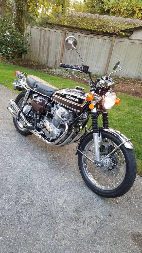 a motorcycle is parked on the side of the road near a fence and some grass