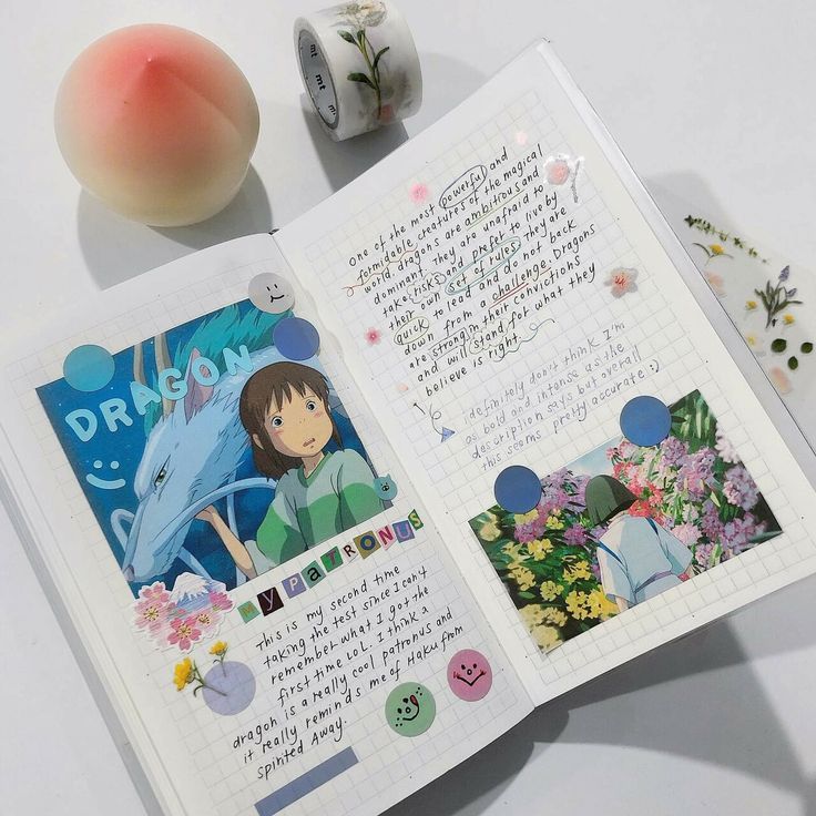 an open book with pictures and stickers on the pages, next to some other items