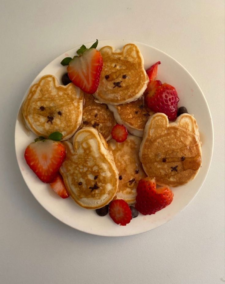 pancakes with strawberries and teddy bears on them are arranged in the shape of hearts