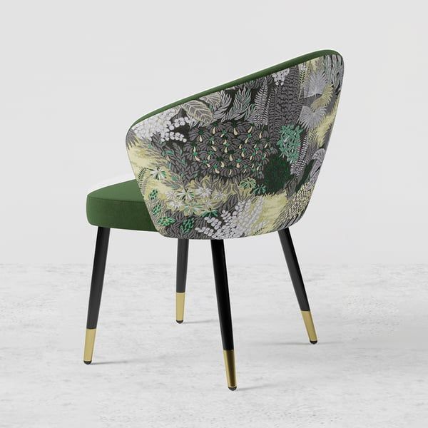 a green chair with black legs and a floral print upholstered on the back