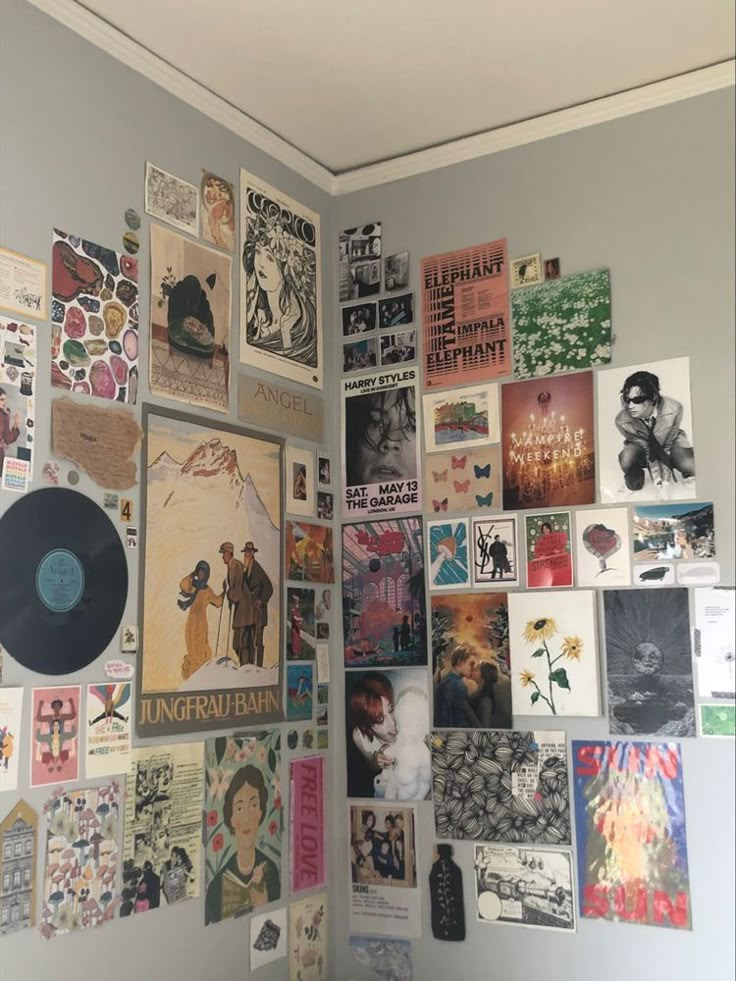 a wall covered in posters and pictures next to a white door with a black vinyl record on it