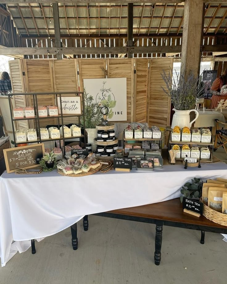 the table is covered with different types of cheeses and other items for sale at an outdoor market