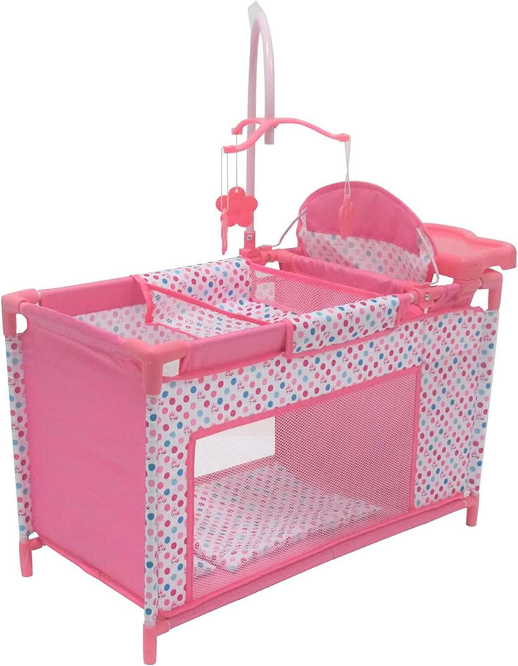 a pink baby crib with blue and white polka dot print on it's sides