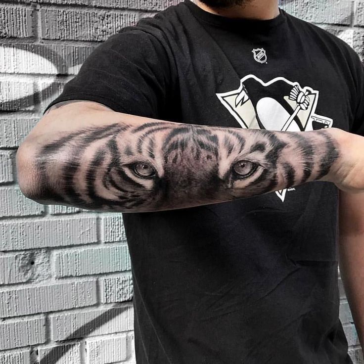 a man with a tiger tattoo on his arm