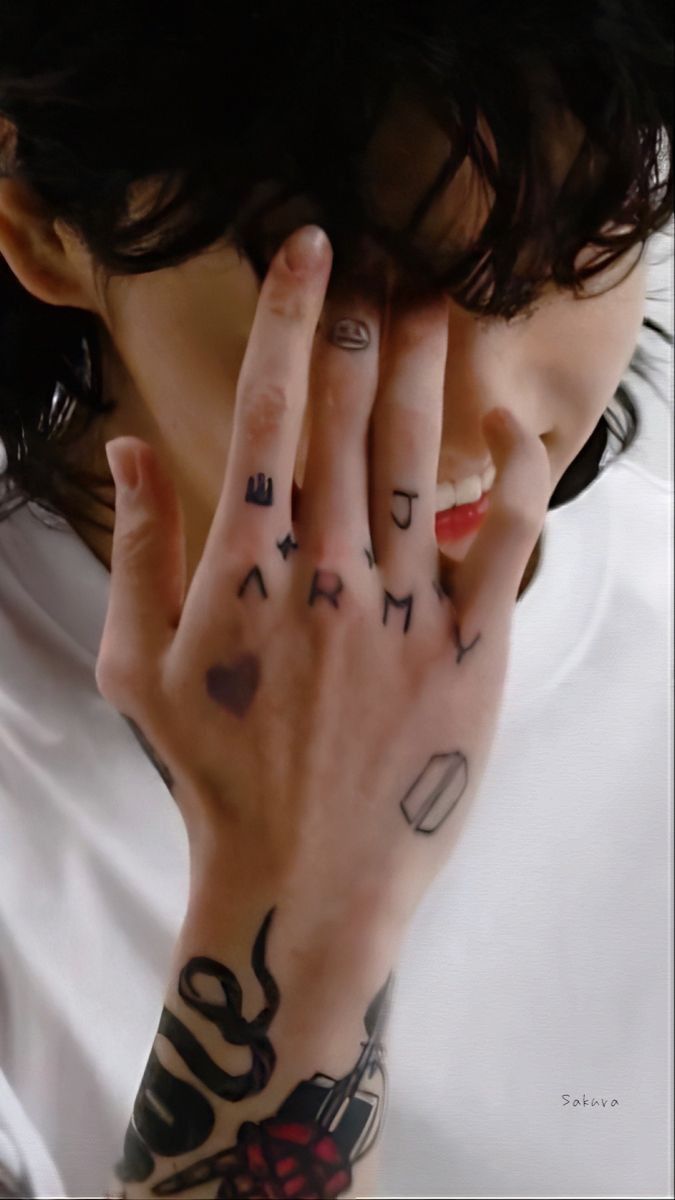 a woman with tattoos covering her face and hand