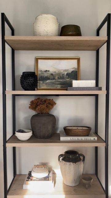 three shelves with vases and pictures on them