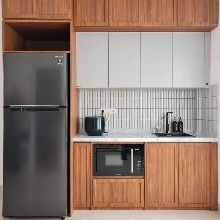 a kitchen with wooden cabinets and stainless steel refrigerator freezer combo in the center, along with white countertops