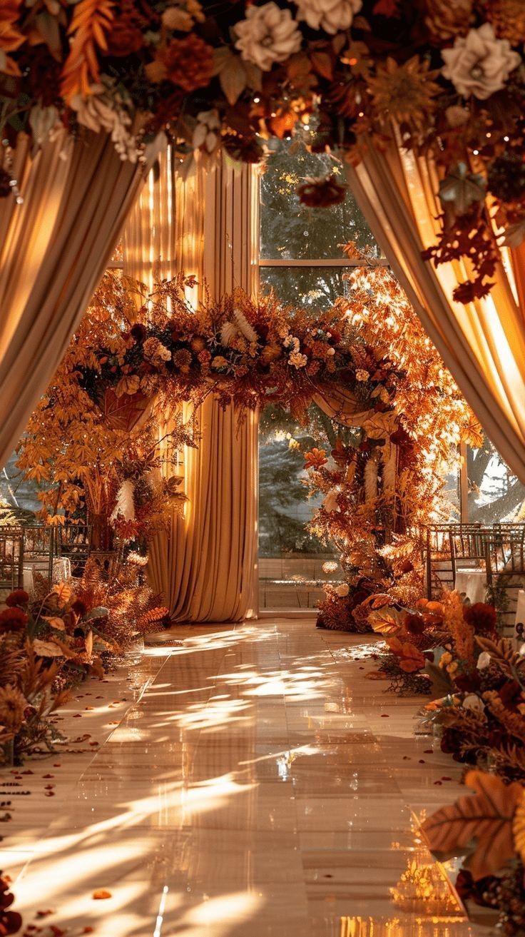 an outdoor wedding ceremony with flowers and greenery on the aisle, surrounded by gold drapes