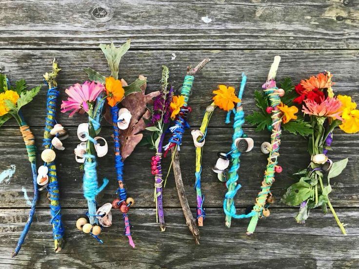 several bracelets with flowers and beads on them sitting on a wooden table next to each other