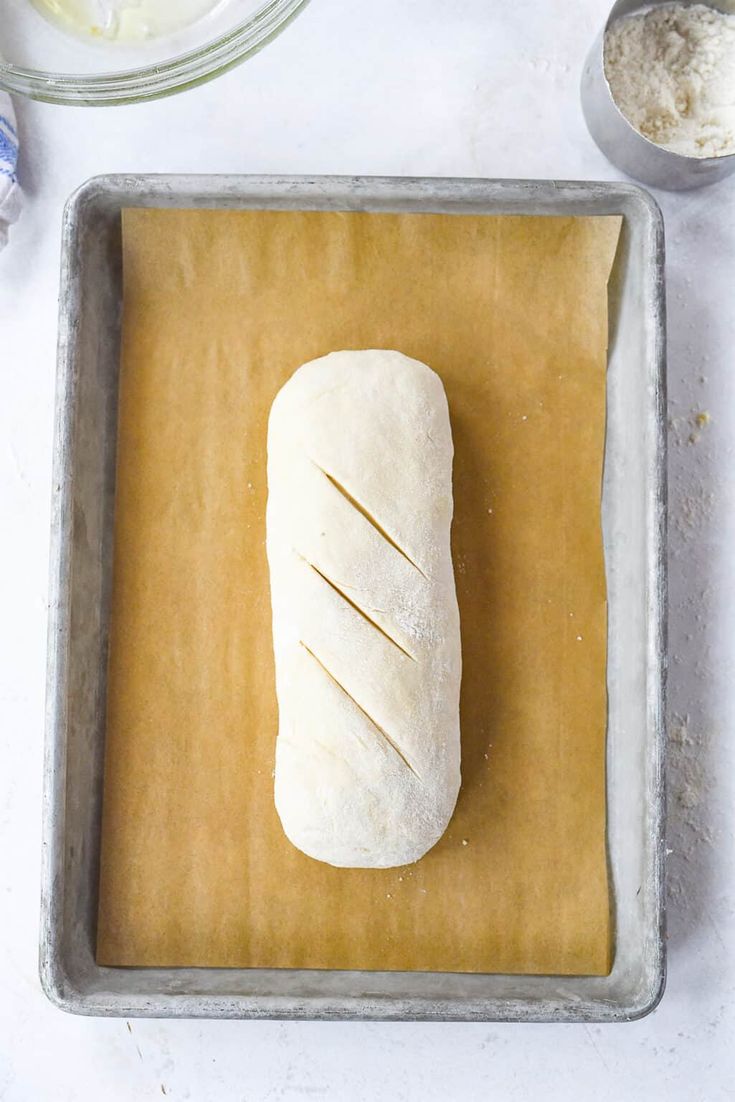 a loaf of bread sitting on top of a baking pan next to other food items