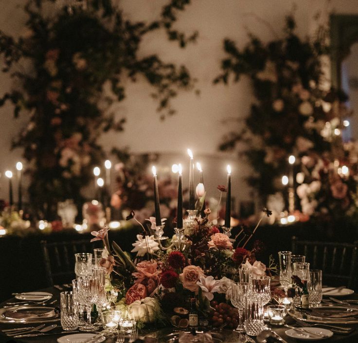 a table is set with candles and flowers for an elegant wedding reception at the mansion