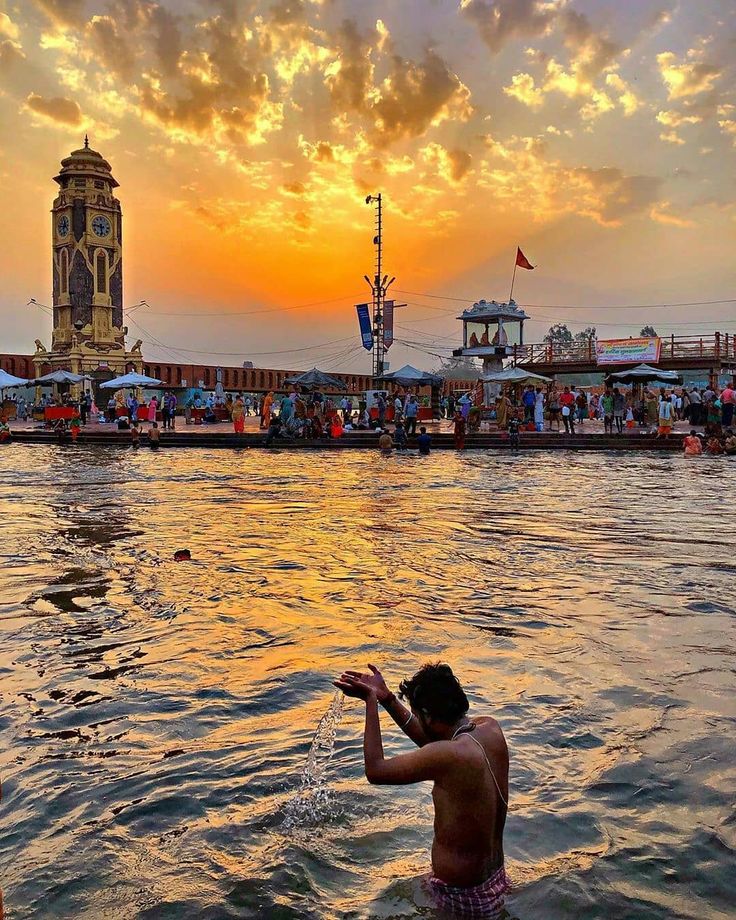 a man standing in the water with his hand up