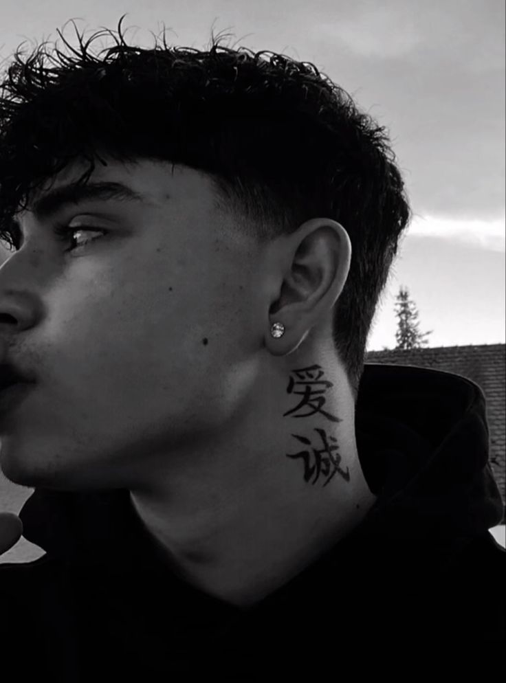 a young man with tattoos on his neck