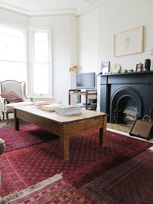 a living room filled with furniture and a fire place next to a large rug on the floor