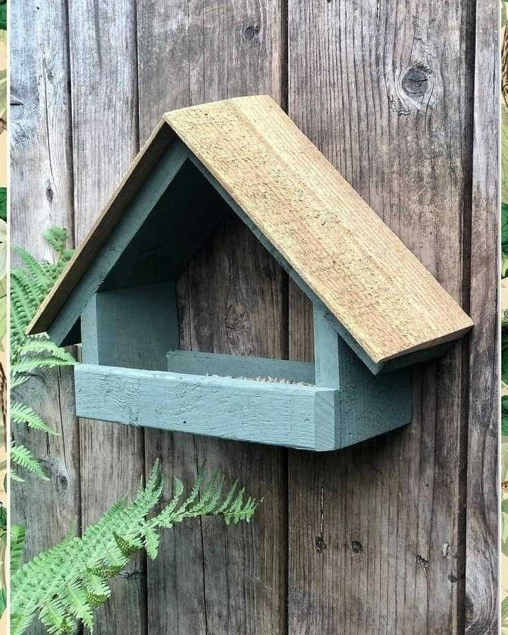 a bird house on the side of a wooden fence