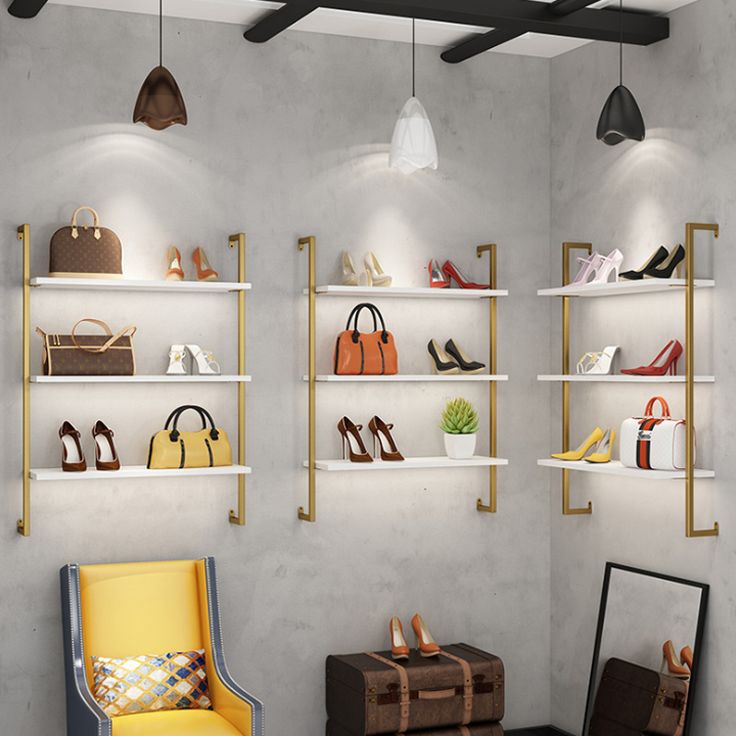 a room filled with lots of different types of shoes and purses on shelves next to a yellow chair