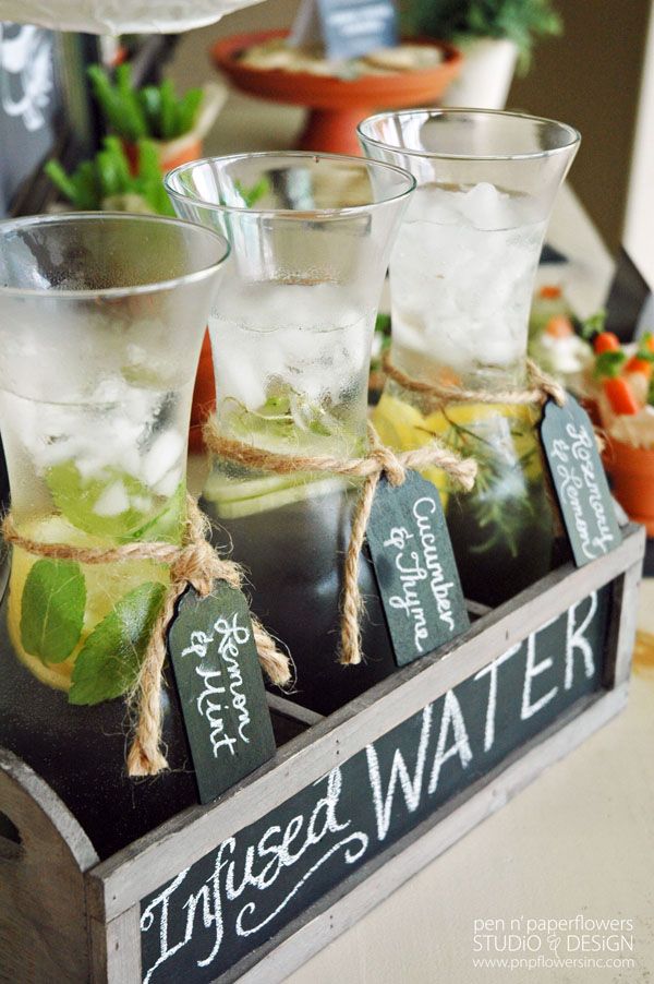 four glasses filled with water and ice on a tray