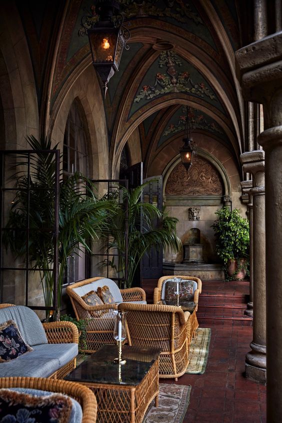 wicker chairs and tables are lined up in an indoor area with arched doorways