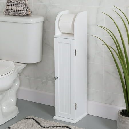 a white toilet sitting next to a plant in a bathroom