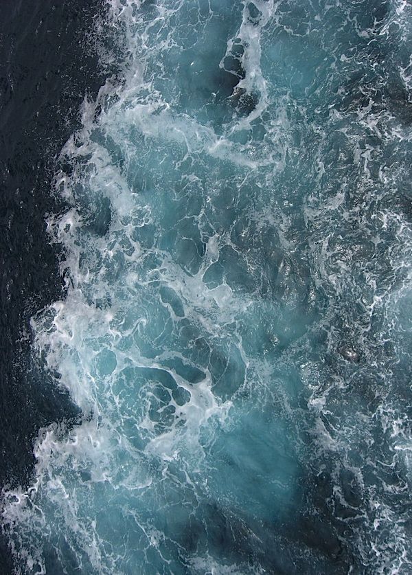 the water is very choppy and blue in this shot from a ship's deck