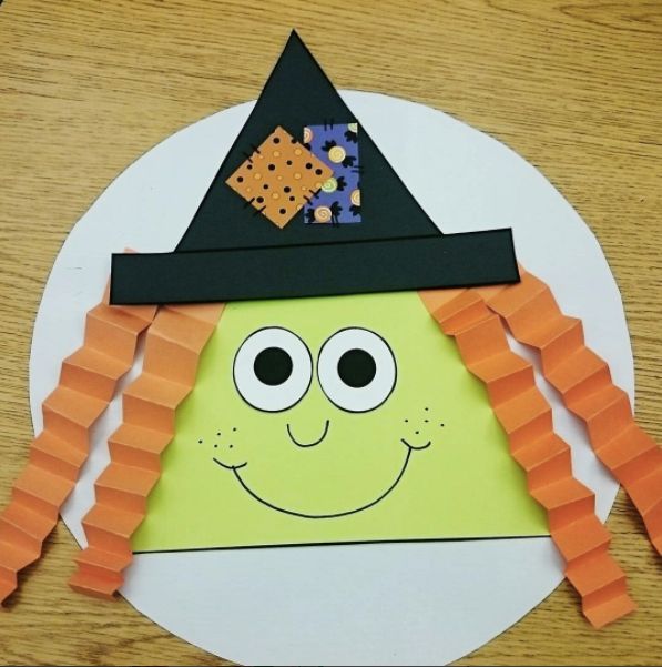 a paper plate with an image of a witch on it and carrots in the shape of a face