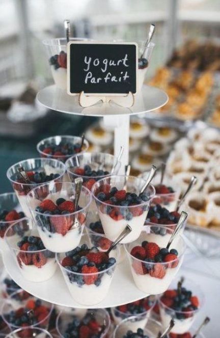 an assortment of desserts and pastries displayed on a table with a sign that says yogurt parfait