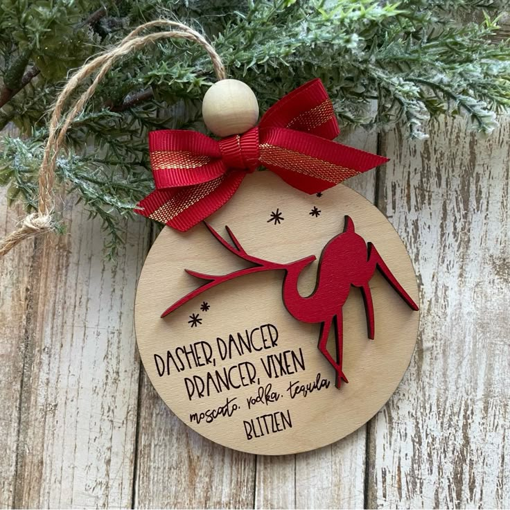 a wooden ornament with a red ribbon on it