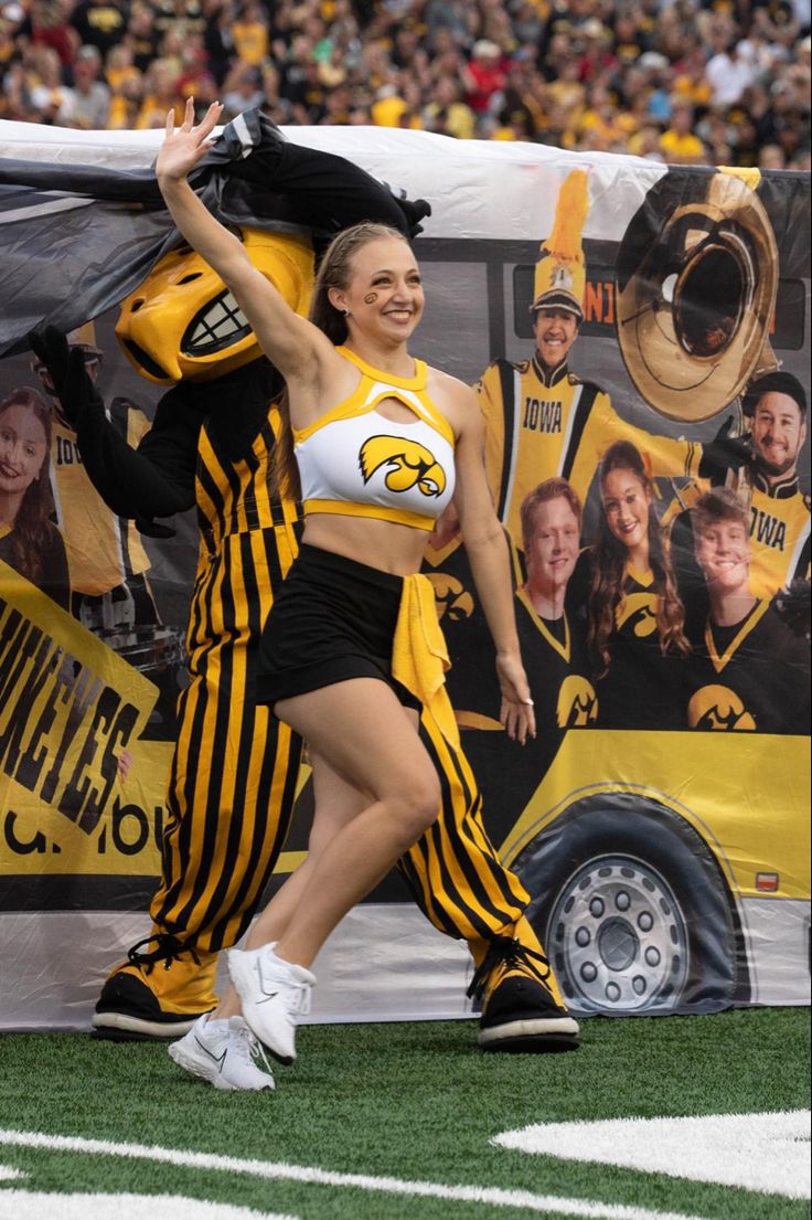 two cheerleaders walking on the field during a football game